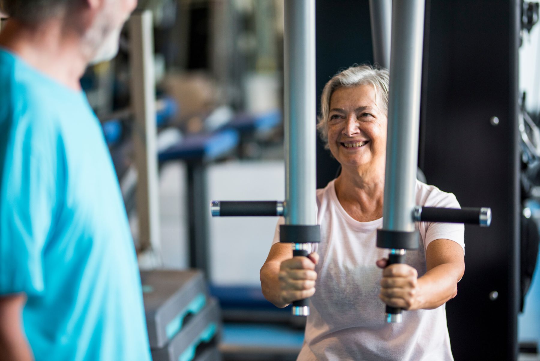 senior woman smiling while exercising on a machine