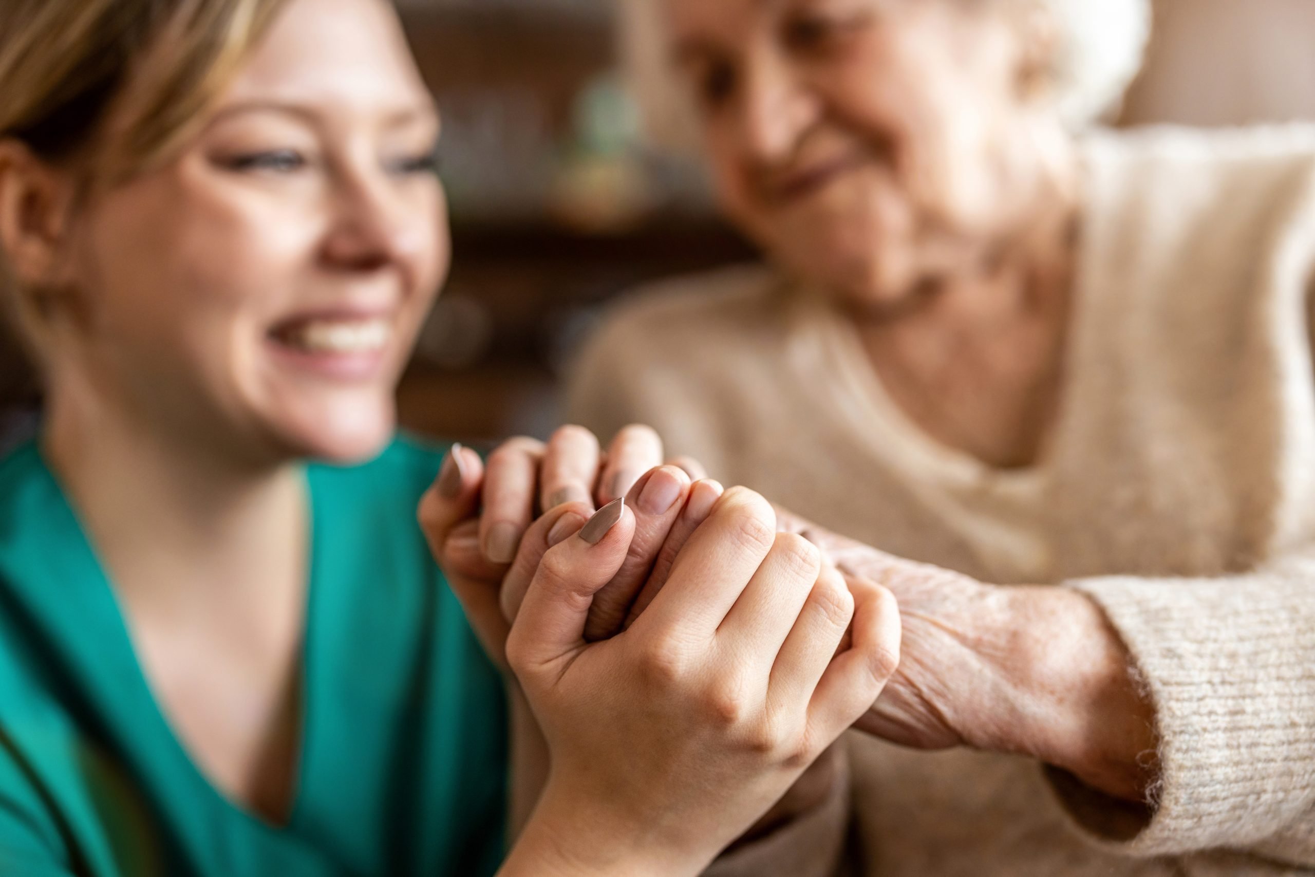 Caregiver and memory care resident hold hands Caregiver and memory care resident hold hands